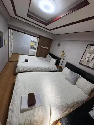 two beds in a small room with at \u65e5\u97d3\u30de\u30f3\u30b7\u30e7\u30f3 in Tokyo