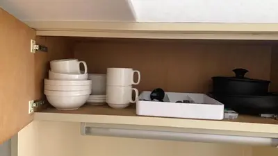 a shelf with bowls and other dishes in a kitchen at \u65e5\u97d3\u30de\u30f3\u30b7\u30e7\u30f3 in Tokyo