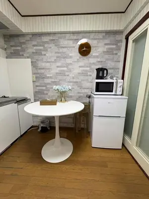 a small kitchen with a white table and a microwave at \u65e5\u97d3\u30de\u30f3\u30b7\u30e7\u30f3 in Tokyo