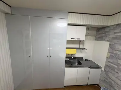 a kitchen with white cabinets and a sink at \u65e5\u97d3\u30de\u30f3\u30b7\u30e7\u30f3 in Tokyo
