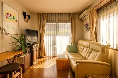 a living room with a couch and a television at GP House in Tokyo