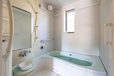 a bathroom with a green tub and a window at GP House in Tokyo