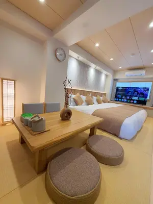 a bedroom with a large bed and a wooden table at SUN House asakusabashi akihabara tokyo in Tokyo