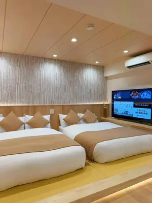 two beds in a room with a flat screen tv at SUN House asakusabashi akihabara tokyo in Tokyo
