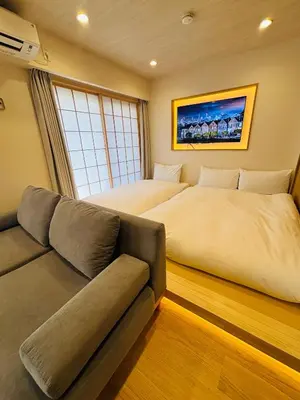 a bedroom with two beds and a couch at SUN House asakusabashi akihabara tokyo in Tokyo