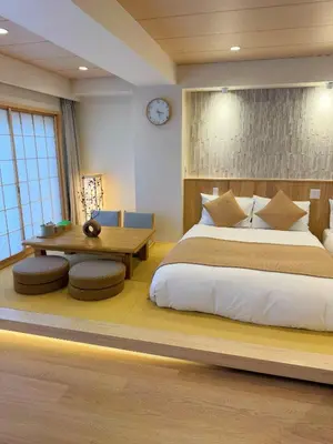 a bedroom with a large bed and a table at SUN House asakusabashi akihabara tokyo in Tokyo