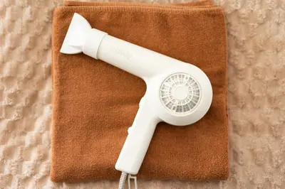 a white hair dryer sitting on top of a towel at Kichi01 \u5927\u4eba\u3082\u5b50\u4f9b\u3082\u3086\u3063\u304f\u308a\u3068\u3067\u304d\u308b\u304a\u90e8\u5c4b in Tokyo