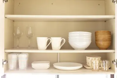 a shelf with dishes and wine glasses and plates at Kichi01 \u5927\u4eba\u3082\u5b50\u4f9b\u3082\u3086\u3063\u304f\u308a\u3068\u3067\u304d\u308b\u304a\u90e8\u5c4b in Tokyo