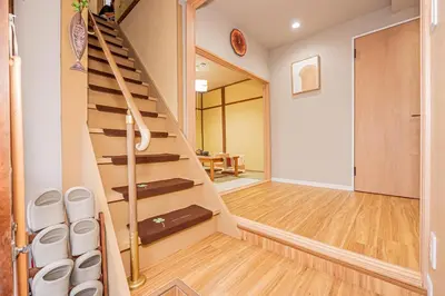a staircase in a house with a hallway and a table at skytree Family Hotel in Tokyo