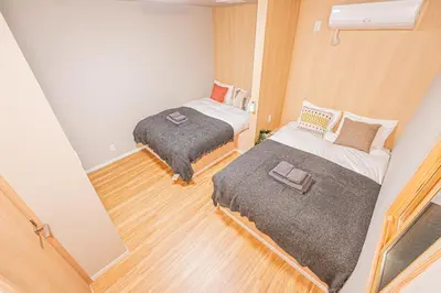 two beds in a small room with wood floors at skytree Family Hotel in Tokyo