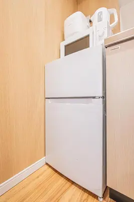 a white refrigerator in a kitchen with a microwave at skytree Family Hotel in Tokyo