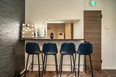 a bar with four blue stools in front of a counter at Kokoon Hotel Yotugi in Tokyo