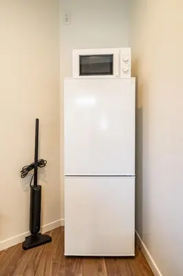 a white refrigerator with a microwave on top of it at Kokoon Hotel Yotugi in Tokyo