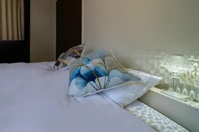 a bed with a pillow on it with a window at Kokoon Hotel Yotugi in Tokyo