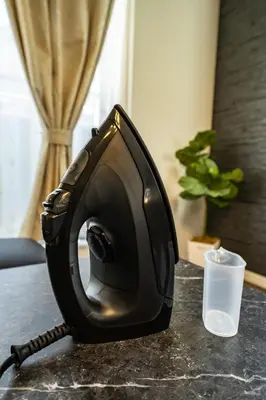a black iron sitting on a table with a glass at Kokoon Hotel Yotugi in Tokyo