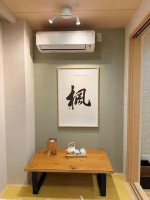 a wooden table in a room with a picture on the wall at M house asakusa kaminarimon tokyo in Tokyo