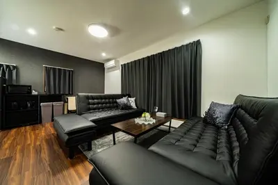 a living room with black couches and a table at Kokoon Hotel Shibamata in Tokyo