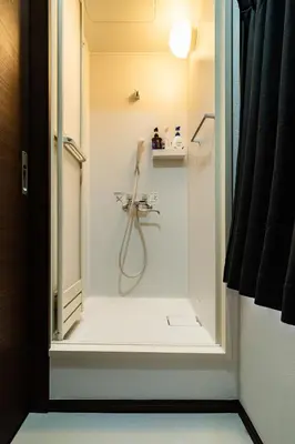 a bathroom with a shower with a glass door at Kokoon Hotel Shibamata in Tokyo