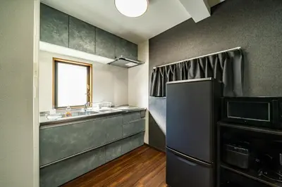 a kitchen with a refrigerator and a sink and a window at Kokoon Hotel Shibamata in Tokyo