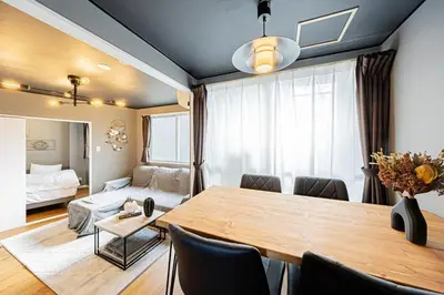 a dining room with a table and a bedroom at Sumu Hotel Shinjuku in Tokyo