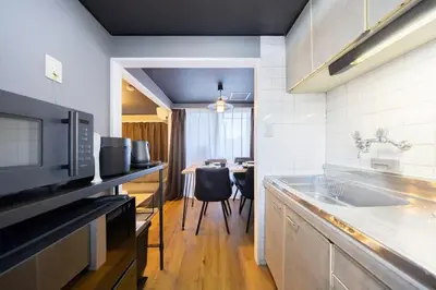 a kitchen with a sink and a table with chairs at Sumu Hotel Shinjuku in Tokyo