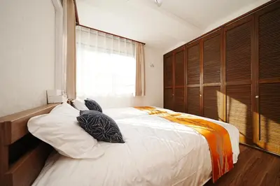 a bedroom with a large white bed with pillows at Tokyo RIRIARU HOTEL \u65b0\u5fa1\u5f92\u753a in Tokyo