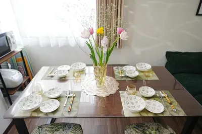 a table with dishes and a vase of flowers on it at Tokyo RIRIARU HOTEL \u65b0\u5fa1\u5f92\u753a in Tokyo