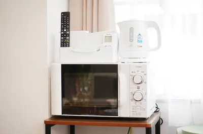 two microwaves stacked on top of each other on a table at Tokyo RIRIARU HOTEL \u65b0\u5fa1\u5f92\u753a in Tokyo