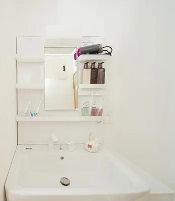 a white bathroom sink with a mirror above it at Tokyo RIRIARU HOTEL \u65b0\u5fa1\u5f92\u753a in Tokyo