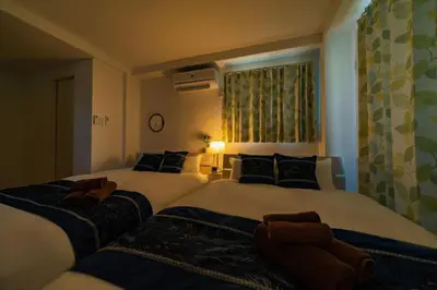 two twin beds in a room with a window at Kokoon Hotel Kitashinjuku in Tokyo