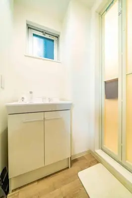a white bathroom with a sink and a window at Kokoon Hotel Kitashinjuku in Tokyo