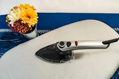 a remote control sitting on a white pillow with a vase of flowers at Kokoon Hotel Kitashinjuku in Tokyo