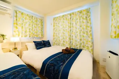 a bedroom with two beds and a window with curtains at Kokoon Hotel Kitashinjuku in Tokyo