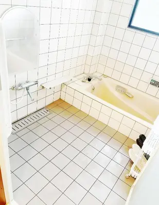 a bathroom with a tub and a tiled floor at \u70df\u96e8\u8f69201 in Tokyo