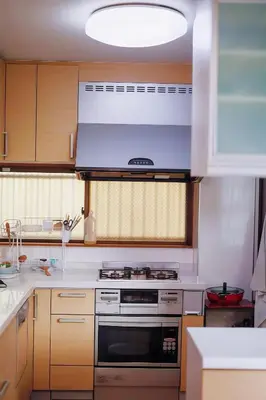a kitchen with wooden cabinets and a stove top oven at \u70df\u96e8\u8f69201 in Tokyo