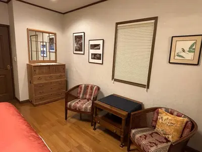 a bedroom with a chair and a table and a window at S & K Garden House in Tokyo