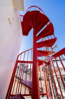 a red spiral staircase on a boat with a blue sky at Kokoon Hotel Yahiro in Tokyo