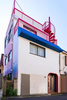a building with a red balcony on top of it at Kokoon Hotel Yahiro in Tokyo