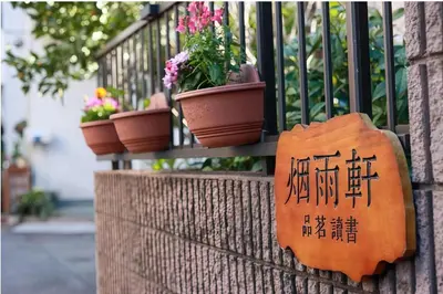 a sign on a wall with potted plants on a balcony at \u70df\u96e8\u8f69 202 in Tokyo