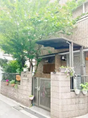 a house with a fence with plants and an umbrella at \u70df\u96e8\u8f69 202 in Tokyo
