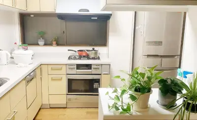 a kitchen with white appliances and potted plants at \u70df\u96e8\u8f69 203 in Tokyo