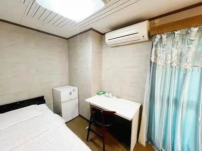a small room with a desk and a bed and a table at \u70df\u96e8\u8f69 303 in Tokyo