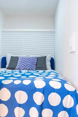 a blue and white bed with a blue and white blanket at Mi-HOTEL OTSUKA in Tokyo