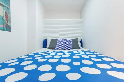 a blue and white bed with a blue and white comforter at Mi-HOTEL OTSUKA in Tokyo