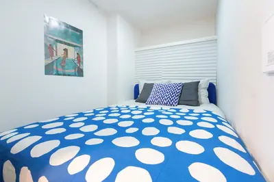 a bedroom with a bed with a blue and white comforter at Mi-HOTEL OTSUKA in Tokyo