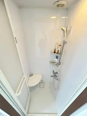 a bathroom with a shower and a toilet at Ueno Sakura House in Tokyo