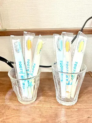 two glasses of toothbrushes sitting on a table at Ueno Sakura House in Tokyo