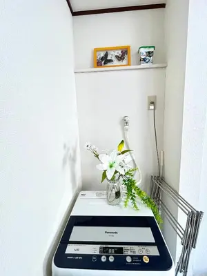 a table with a tablet and flowers on it at Ueno Sakura House in Tokyo