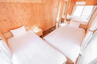 two beds in a small room with a window at Screamer 2 Hostel in Tokyo