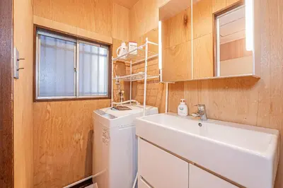 a small bathroom with a sink and a washing machine at Screamer 2 Hostel in Tokyo